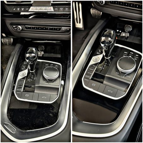 Mittelkonsole eines Fahrzeugs mit Schaltknüppel und Steuerungselementen.